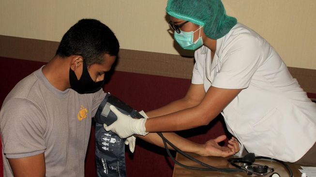 Seorang pasien positif COVID-19 yang sudah dinyatakan sembuh melakukan tes tekanan darah di kantor Palang Merah Indonesia (PMI) ketika hendak mendonorkan plasma darahnya Kupang, NTT, Selasa (19/5).  [ANTARA FOTO/Kornelis Kaha]