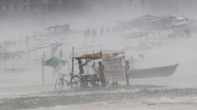 Ilustrasi foto seorang warga dalam terpal kiosnya di tengah badai di tepi Sungai Gangga di Allahabad, India, Senin (13/10/2017). Rabu (2/5/2018) sejumlah wilayah di India utara dan barat juga dilanda topan badai yang menewaskan puluhan orang. (REUTERS/Jitendra Prakash)