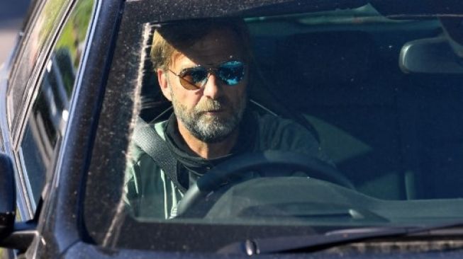 Manajer Liverpool Jurgen Klopp meninggalkan arena latihan tim di Melwood, 20 Mei 2020. [AFP]