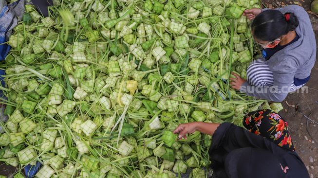 Warga memilih kulit ketupat yang akan dibeli di Pasar Palmerah, Jakarta Pusat, Kamis (21/5).[Suara.com/Alfian Winanto]