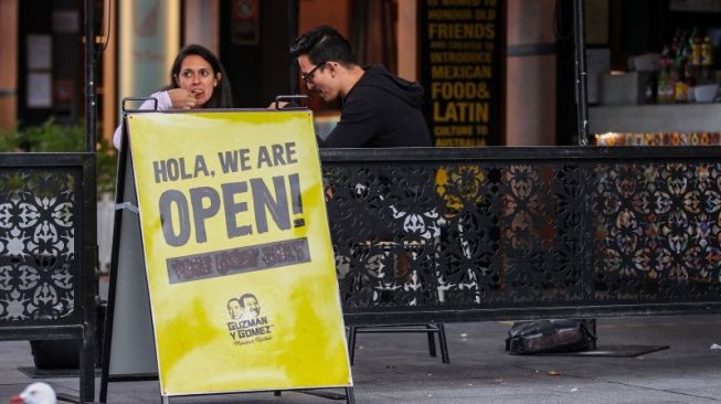 Penduduk setempat menyantap makanan di salah satu restoran, di Darling Harbour di Sydney, Australia, Sabtu (17/5/2020). Sydney mulai melonggarkan beberapa pembatasan COVID-19 sejak 15 Mei lalu yang memungkinkan orang-orang pergi ke berbagai pantai, pub, dan restoran untuk kegiatan rekreasi. ANTARA FOTO/Xinhua-Bai Xuefei/hp. 