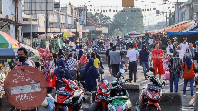 Warga berlalu - lalang di sekitaran rel kereta api Pasar Anyar, Bogor, Jawa Barat, Jumat (22/5). [Suara.com/Alfian Winanto]
