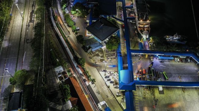 Foto aerial kendaraan logistik tujuan Sumatera antre memasuki kapal di Pelabuhan Merak Banten, Kamis (21/5) malam. [ANTARA FOTO/Galih Pradipta]