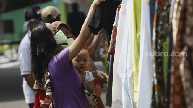 Warga memilih baju bekas layak pakai hasil sumbangan di RT 02 RW 04 Kelurahan Jati Padang, Jakarta, Jumat (22/5).  [Suara.com/Angga Budhiyanto]