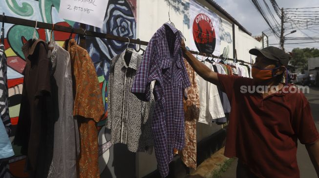 Warga memilih baju bekas layak pakai hasil sumbangan di RT 02 RW 04 Kelurahan Jati Padang, Jakarta, Jumat (22/5).  [Suara.com/Angga Budhiyanto]