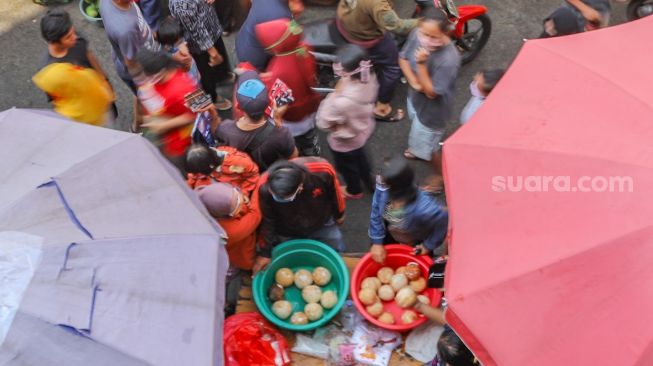 Warga berkerumun saat berbelanja di Pasar Kebayoran Lama, Jakarta Selatan, Sabtu (23/5). [Suara.com/Alfian Winanto]
