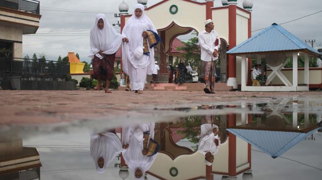 Jamaah Tarekat Syattariah usaimelaksanakan shalat Idul Fitri 1441 Hijriah di halaman Masjid Syaikhuna Habib Muda Seunagan Desa Peuleukung, Seunagan Timur, Nagan Raya, Aceh, Sabtu (23/5). [ANTARA FOTO/Syifa Yulinnas]