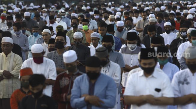 Umat Islam melaksanakan shalat Idul Fitri 1 Syawal 1441 Hijriah secara berjamaah di ruas Jalan Jenderal Sudirman, Kranji, Bekasi, Jawa Barat, Minggu (24/5). [Suara.com/Angga Budhiyanto]