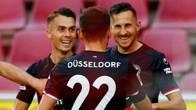 Erik Thommy (kiri) merayakan golnya bersama rekan setimnya setelah membawa Fortuna Duesseldorf memimpin 2-0 atas FC Cologne dalam lanjutan Liga Jerman. Tilo SCHMUELGEN / POOL / AFP