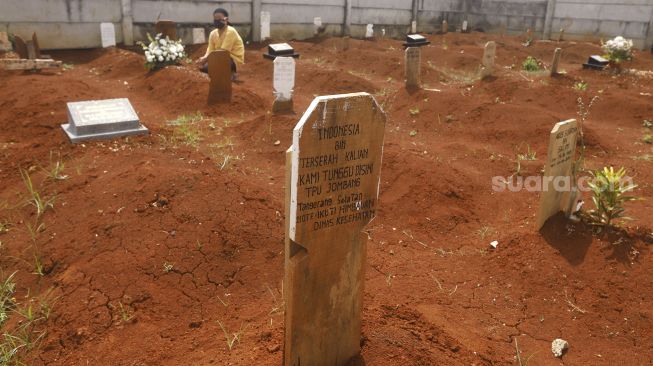 Seorang warga berziarah di dekat makam dengan nisan bertuliskan Indonesia bin Terserah di TPU Jombang, Tangerang Selatan, Selasa (26/5). [Suara.com/Angga Budhiyanto]
