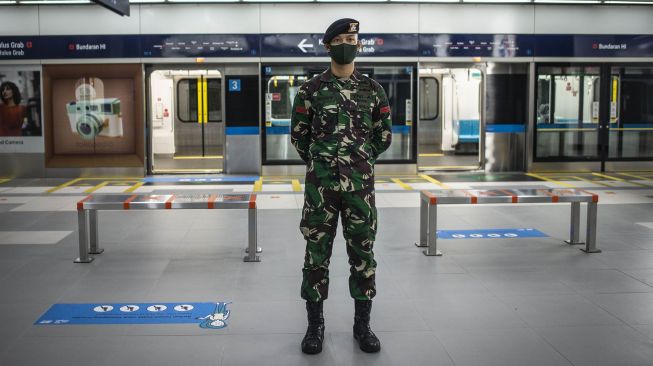 Prajurit TNI AD (kiri) berjaga di Stasiun MRT Bundaran HI, Jakarta, Rabu (27/5).  [ANTARA FOTO/Aprillio Akbar]