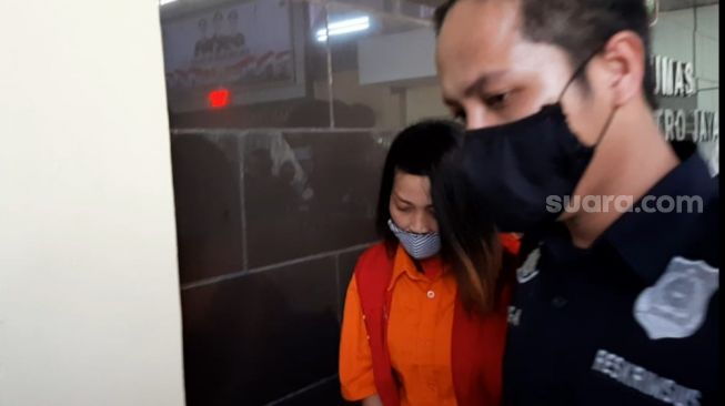 Marta Sari (mengenakan rompi oranye), pelaku penyebaran video asusila yang disebut mirip Syahrini dihadirkan dalam konfrensi pers di Polda Metro Jaya, Kamis (28/5/2020). [Herwanto/Suara.com]