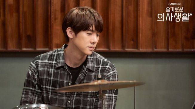 Aktor Yoo Yeon Seok berperan sebagai dokter sekaligus drummer dalam serial Hospital Playlist. (Instagram/@hospitalplaylist_official)