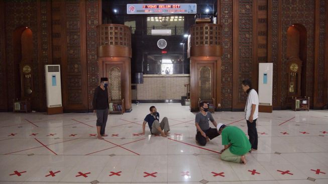 Sejumlah petugas mempersiapkan penanda jarak untuk persiapan pelaksanaan Salat Jumat di Masjid Agung Al Barkah kota Bekasi, Jawa Barat, Kamis (28/5/2020). [ANTARA FOTO/Paramayuda]