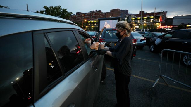 Warga New York membeli minuman saat menikmati tayangan film di bioskop drive in di masa pandemi Covid-19 di Queens, New York City, Amerika Serikat pada 27 Mei 2020.  [Foto/Anadolu Agency]