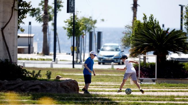 Anak-anak bermain bola di taman setelah pemerintah Turki mengizinkan anak-anak 14 tahun meninggalkan rumah  di Antalya, Turki pada 27 Mei 2020.  [Foto/Anadolu Agency]