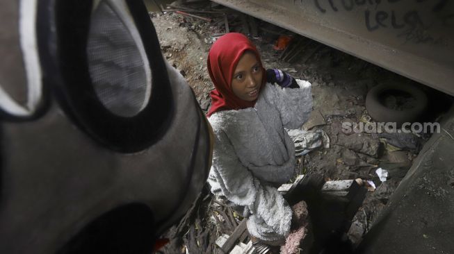 Selvi (20) mengenakan kostum badut kelinci bersiap mengamen di jembatan di kawasan Cibubur, Jakarta, Kamis (28/5). [Suara.com/Angga Budhiyanto]