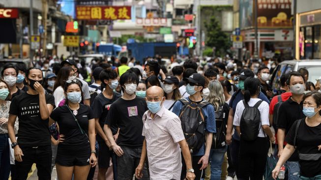 Para pengunjuk rasa melihat ke arah sekelompok polisi anti huru hara di kawasan Mongkok, Hong Kong, Rabu (27/5). [Anthony Wallace / AFP]