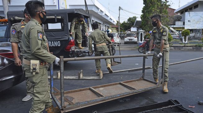 Sejumlah anggota Polisi Pamong Praja membongkar kios liar di Jalan Diponegoro Kota Serang, Banten, Jumat (29/5). [ANTARA FOTO/Asep Fathulrahman]