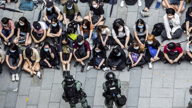 Polisi anti huru-hara menahan sekelompok orang selama demonstrasi di kawasan Causeway Bay, Hong Kong, Rabu (27/5). [Isaac Lawrence / AFP]