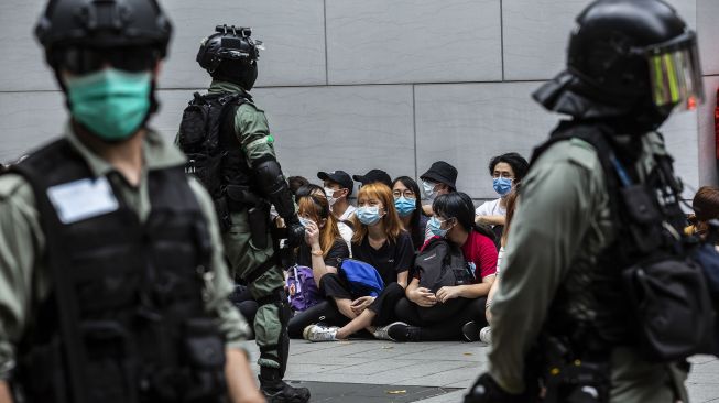 Polisi anti huru-hara menahan sekelompok orang selama demonstrasi di kawasan Causeway Bay, Hong Kong, Rabu (27/5). [Isaac Lawrence / AFP]