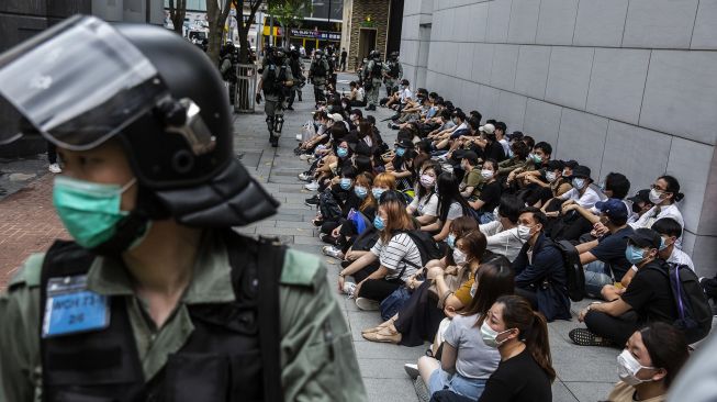 Polisi anti huru-hara menahan sekelompok orang selama demonstrasi di kawasan Causeway Bay, Hong Kong, Rabu (27/5). [Isaac Lawrence / AFP]