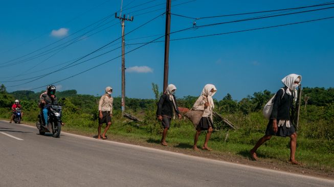 Sejumlah warga Baduy Dalam menggunakan masker berjalan menuju kota Rangkasbitung di Kecamatan Cimarga, Lebak, Banten, Sabtu (30/5). [ANTARA FOTO/Muhammad Bagus Khoirunas]