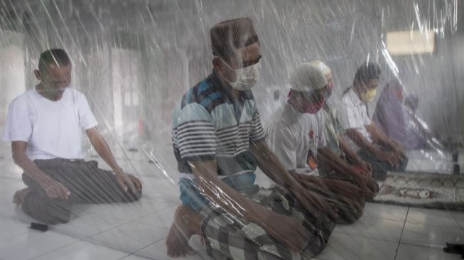 Warga menjalankan ibadah shalat zuhur dengan memberi jarak antar jamaah dengan sekat plastik di Masjid Daarul Wasiilah Desa Brujul, Jaten, Karanganyar, Jawa Tengah, Sabtu (30/5). [ANTARA FOTO/Mohammad Ayudha]