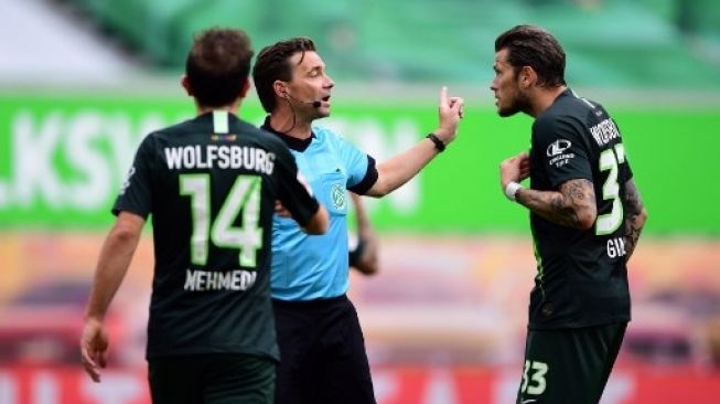 Pemain Wolfsburg memprotes keputusan wasit saat menghadapi Eintracht Frankfurt di Volkswagen Arena, Sabtu (30/5/2020). [AFP]