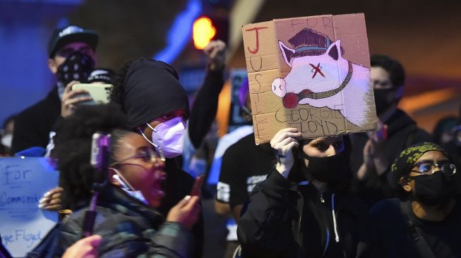 Para pengunjuk rasa berhadapan dengan polisi ketika mereka memasuki interstate 580 di Oakland, California, Jumat (29/5). [Josh Edelson / AFP