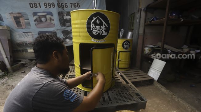 Perajin melakukan pengecekan wastafel portable berbahan baku drum di workshop Galuh Creatives, Tangerang Selatan, Banten, Sabtu (30/5). [Suara.com/Angga Budhiyanto]