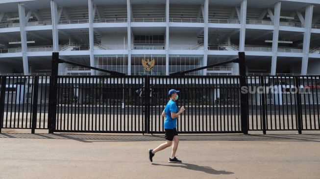 Warga menggunakan masker berolahraga di kawasan Gelora Bung Karno, Jakarta, Minggu (31/5). [Suara.com/Alfian Winanto]