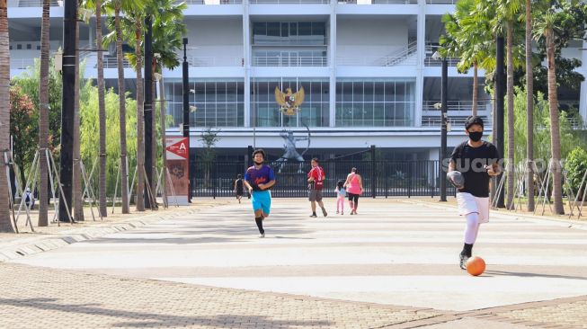 Anak - anak bermain bola di Kompleks Olahraga Gelora Bung Karno, Jakarta Pusat, Minggu (31/5). [Suara.com/Alfian Winanto]