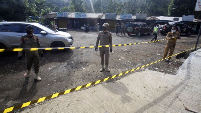 Sejumlah petugas Satpol PP menyegel akses masuk ke lokasi warung pedagang kaki lima (PKL) di kawasan Puncak, Kabupaten Bogor, Jawa Barat, Senin (1/6). . [ANTARA FOTO/Yulius Satria Wijaya]