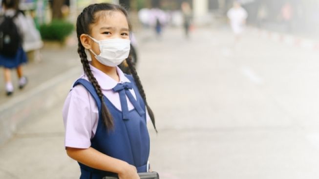 Anak sekolah memakai masker. (Shutterstock)
