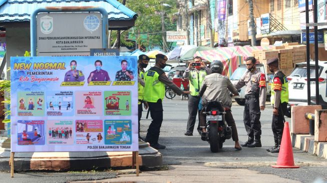 Sejumlah personel kepolisian berjaga di pintu masuk Pasar Sudimampir di Banjarmasin, Kalimantan Selatan, Senin (1/6).  [ANTARA FOTO/Bayu Pratama]
