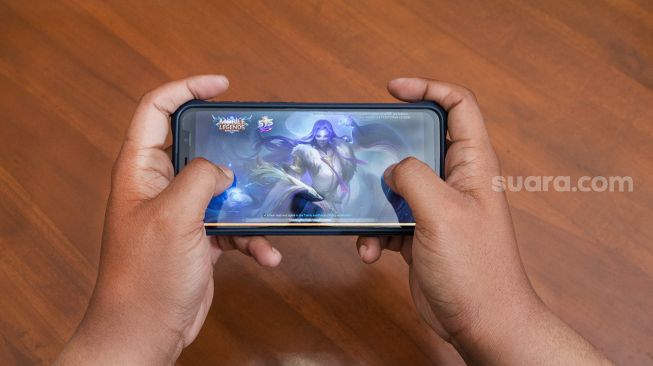 Seorang gamers membuka aplikasi game Mobile Legends di Jakarta, Minggu (31/5). [Suara.com/Alfian Winanto]
