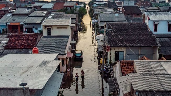 Sejumlah warga beraktifitas di tengah banjir rob yang merendam permukiman mereka di Desa Sriwulan, Sayung, Demak, Jawa Tengah, Senin (1/6). [ANTARA FOTO]