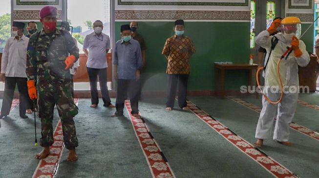 Jusuf Kalla memantau proses penyemprotan disinfektan di Masjid Agung Al Azhar, Jakarta Selatan, Rabu (3/6). [Suara.com/Alfian Winanto]