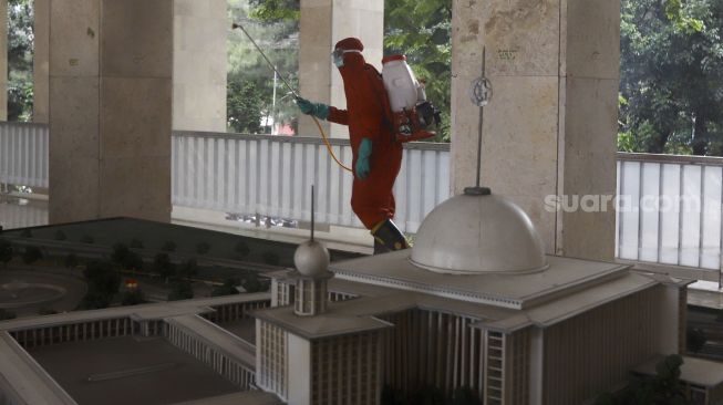 Petugas pemadam kebakaran melakukan penyemprotan cairan disinfektan di Masjid Istiqlal, Jakarta, Rabu (3/6). [Suara.com/Angga Budhiyanto]