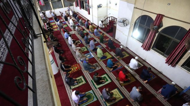 Warga Gaza bersiap melakukan salat subuh berjamaah dengan menerapkan protokol kesehatan seperti menjaga jarak, memakai masker, dan mencuci tangan di Masjid Al-Buhari di Deir Al-Balah, Gaza pada 3 Juni 2020.  [Foto/Anadolu Agency]