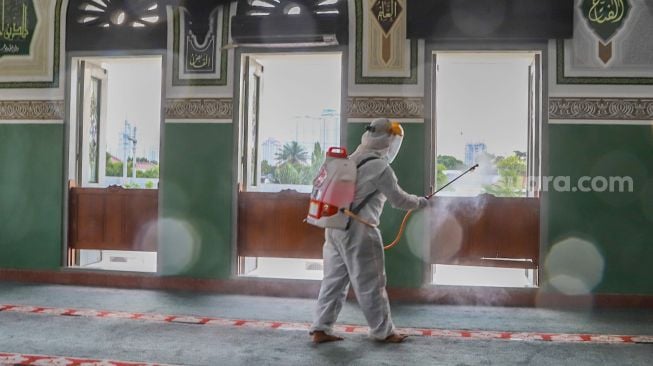 Petugas menyemprotkan disinfektan jendela - jendela di dalam Masjid Agung Al-Azhar, Jakarta Selatan, Rabu (3/6). [Suara.com/Alfian Winanto]