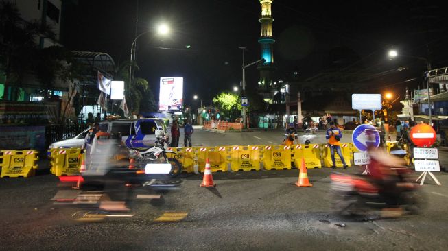 Petugas berjaga di Jalan Rungkut Menanggal yang ditutup di Surabaya, Jawa Timur, Kamis (4/6). [ANTARA FOTO/Didik Suhartono]