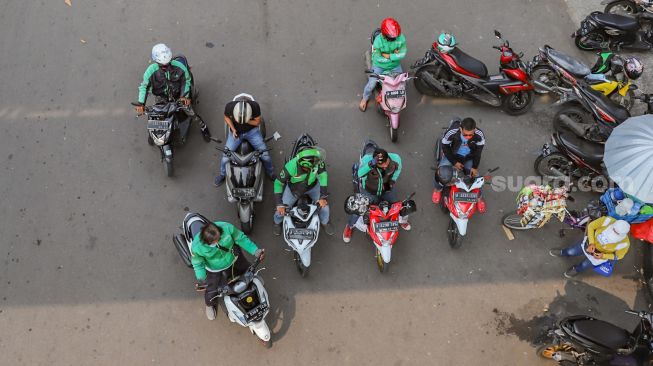 Para pengemudi ojek online menunggu orderan di daerah Kalibata, Jakarta Selatan, Sabtu (6/6). [Suara.com/Alfian Winanto]