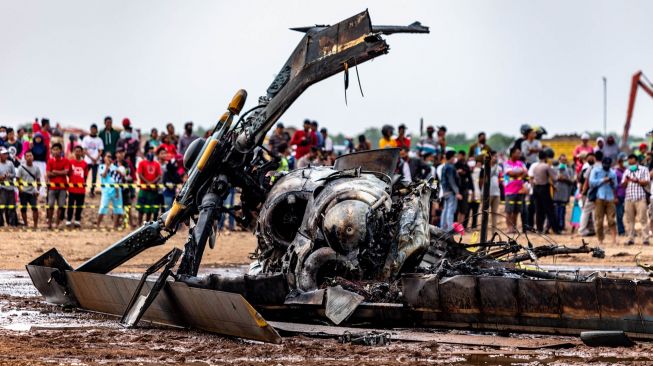 Sejumlah warga menyaksikan bangkai helikopter yang jatuh di Kawasan Industri Kendal (KIK), Kabupaten Kendal, Jawa Tengah, Sabtu (6/6/2020).  [ANTARA FOTO/Aji Styawan]