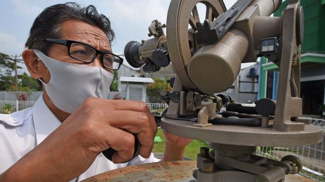 Petugas BMKG (Badan Meteorologi Klimatologi dan Geofisika) memeriksa alat ukur penguapan (Open Pan Evaporimeter) di Laboratorium Terbuka BMKG Serang, Banten, Sabtu (6/6/2020). [ANTARA FOTO/Asep Fathulrahman]