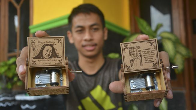 Perajin kotak musik menunjukkan hasil kerajinannya di Kabupaten Jombang, Jawa Timur, Sabtu (6/6). [ANTARA FOTO/Syaiful Arif]