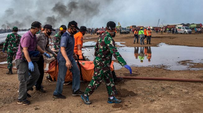 Petugas gabungan mengevakuasi jenazah dari sebuah helikopter yang jatuh di Kawasan Industri Kendal (KIK), Kabupaten Kendal, Jawa Tengah, Sabtu (6/6/2020).  [ANTARA FOTO/Aji Styawan]