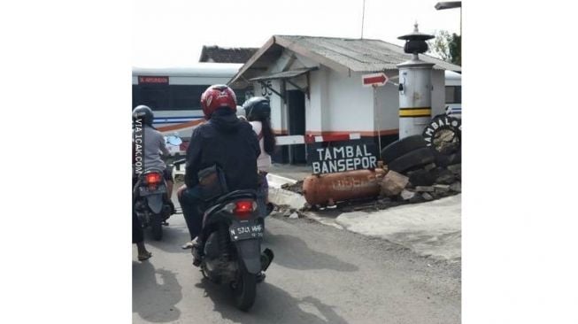 Tukang tambal ban ini sudah bosan dengan ban biasa yak, beralih ke ban kereta api (1cak.com)