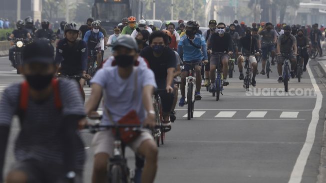 Sejumlah warga berolahraga menggunakan sepeda di Jalan Jenderal Sudirman, Jakarta, Minggu (7/6). [Suara.com/Angga Budhiyanto]